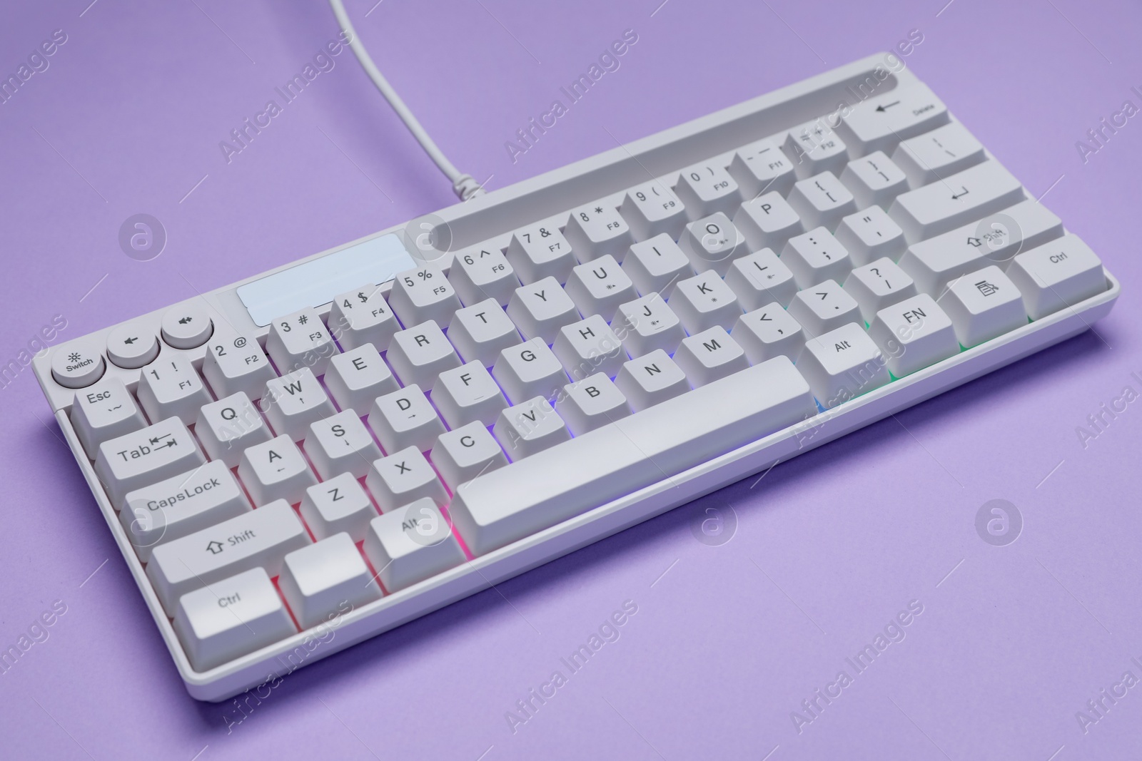 White keyboard with RGB lighting on violet background, closeup Photo of White keyboard with RGB lighting on violet background, closeup