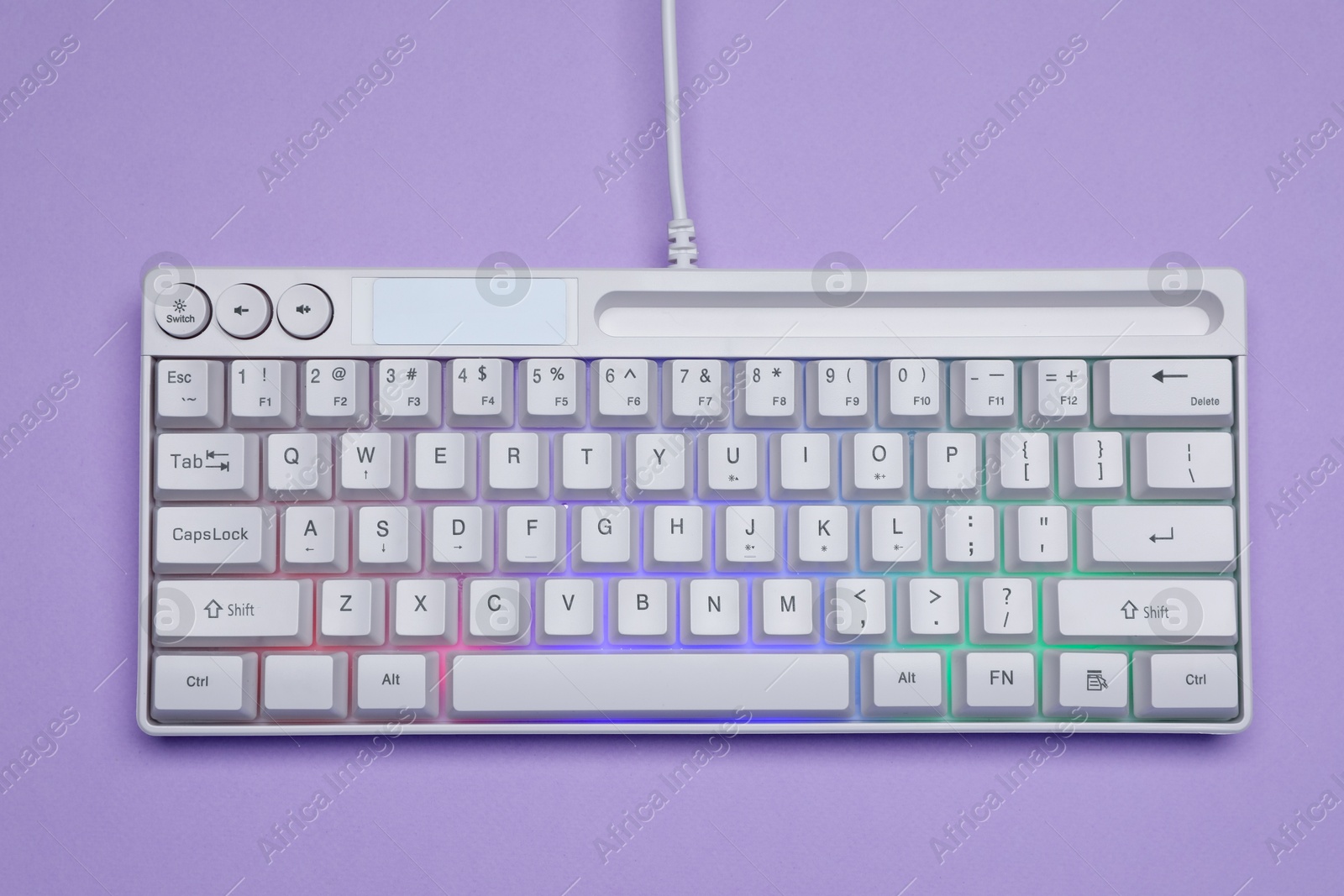 White keyboard with RGB lighting on violet background, top view Photo of White keyboard with RGB lighting on violet background, top view
