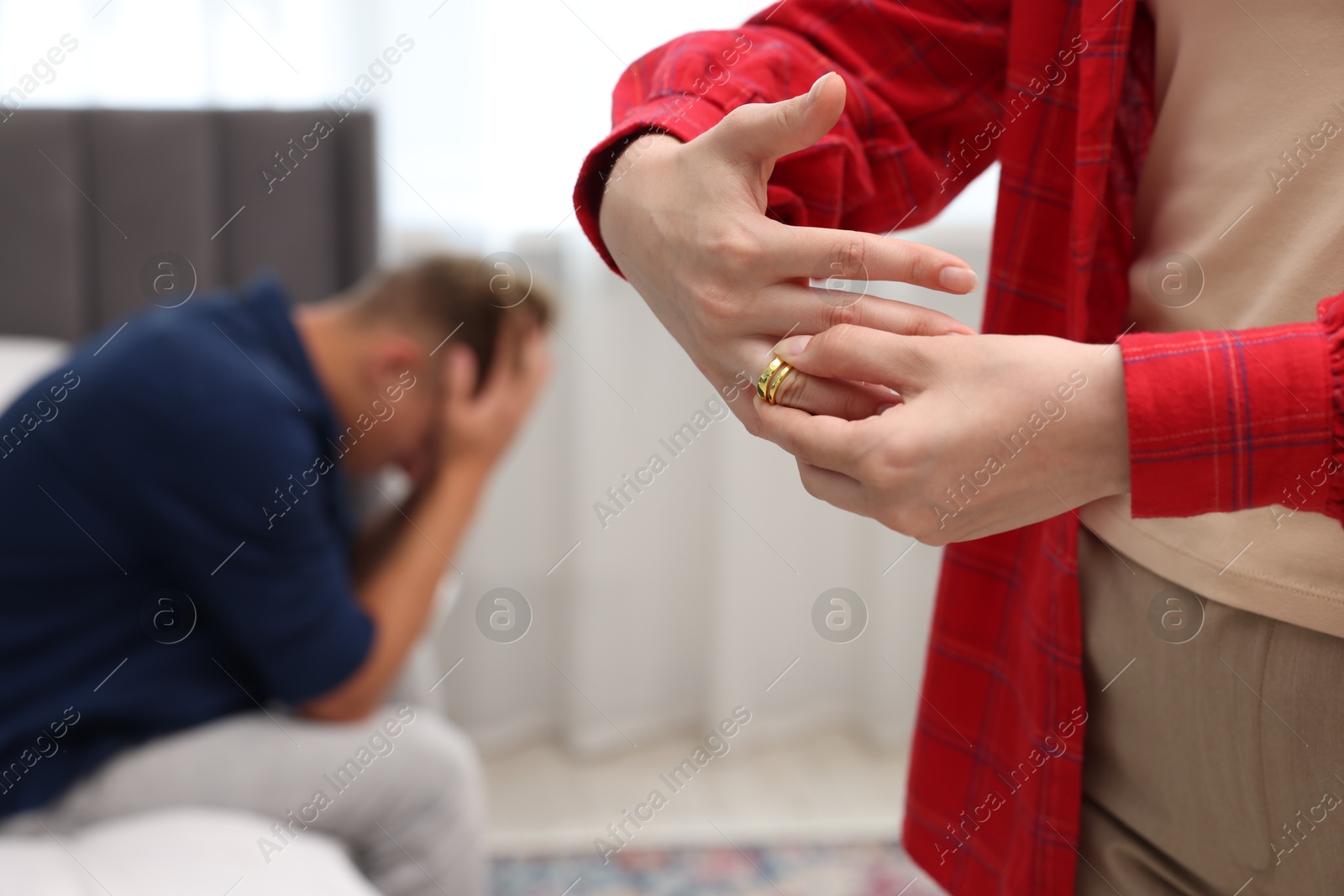 Woman taking off engagement ring after her husband's betrayal indoors, selective focus Photo of Woman taking off engagement ring after her husband's betrayal indoors, selective focus