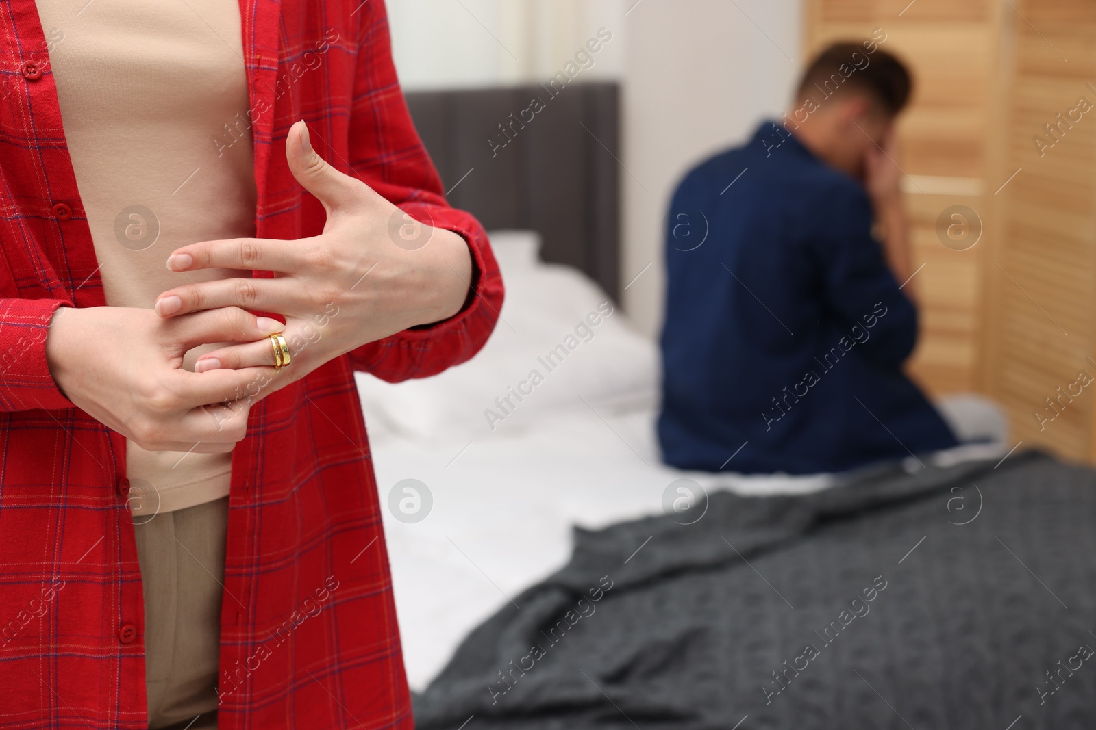 Woman taking off engagement ring after her husband's betrayal indoors, selective focus Photo of Woman taking off engagement ring after her husband's betrayal indoors, selective focus