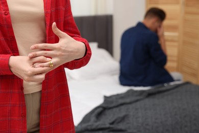 Photo of Woman taking off engagement ring after her husband's betrayal indoors, selective focus