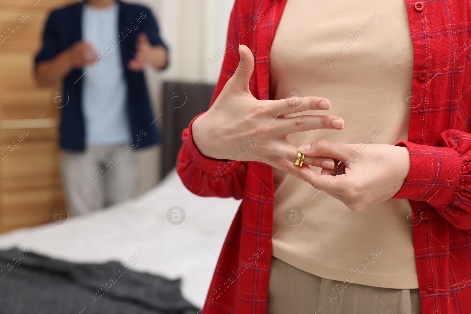 Woman taking off engagement ring after her husband's betrayal indoors, selective focus Photo of Woman taking off engagement ring after her husband's betrayal indoors, selective focus
