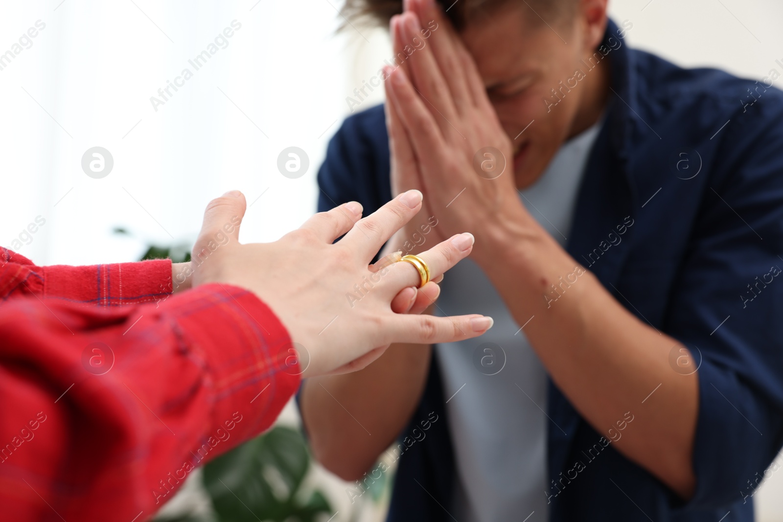 Woman taking off engagement ring after her husband's betrayal indoors, selective focus Photo of Woman taking off engagement ring after her husband's betrayal indoors, selective focus