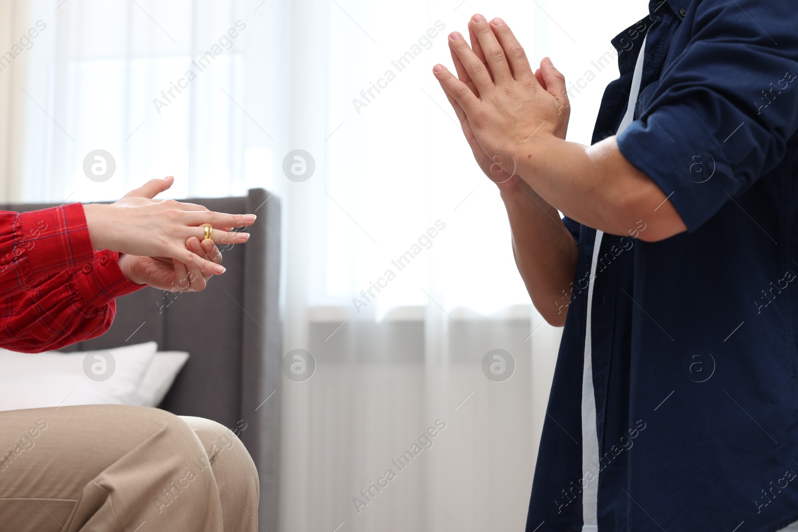Woman taking off engagement ring after her husband's betrayal indoors, closeup Photo of Woman taking off engagement ring after her husband's betrayal indoors, closeup