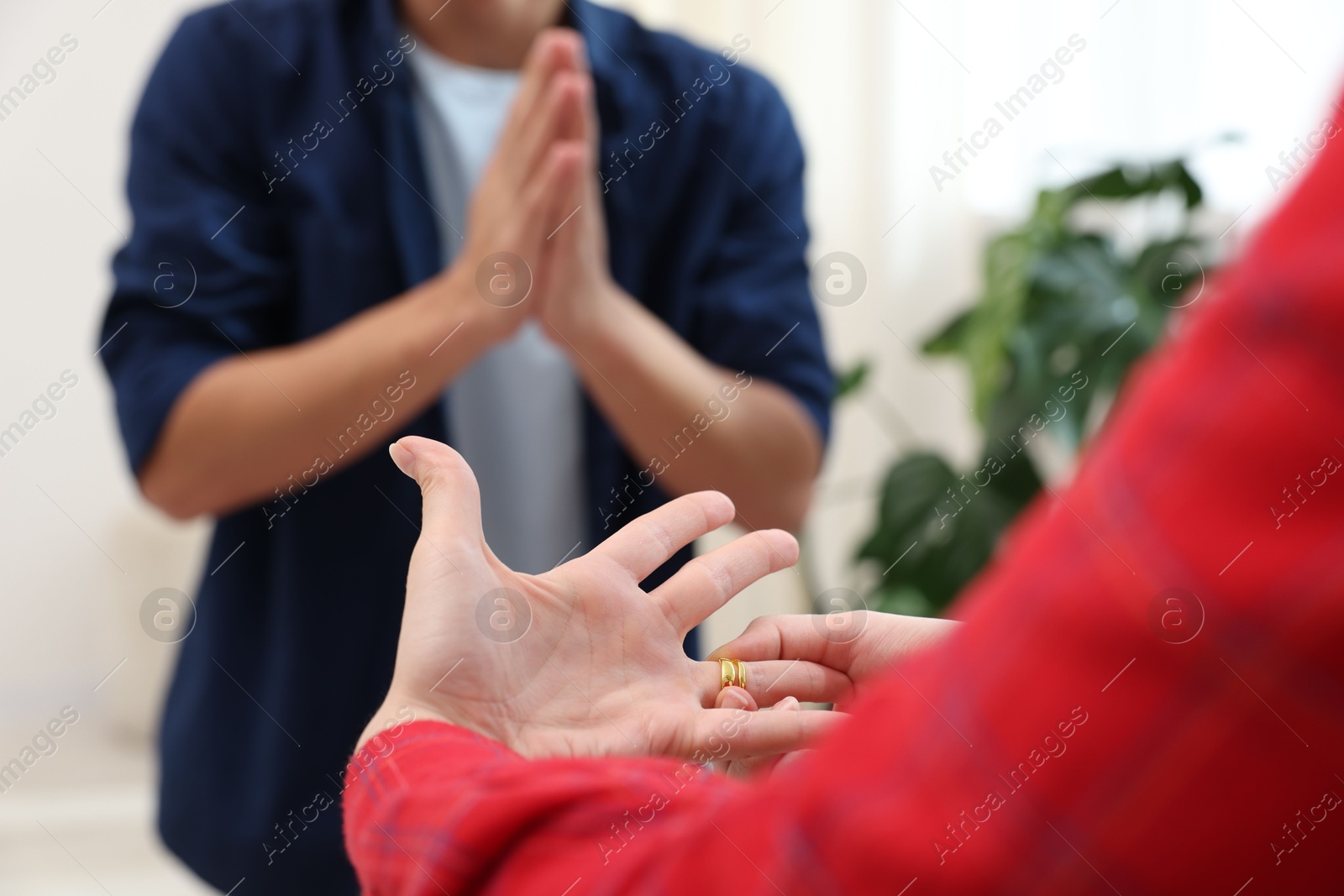 Woman taking off engagement ring after her husband's betrayal indoors, selective focus Photo of Woman taking off engagement ring after her husband's betrayal indoors, selective focus