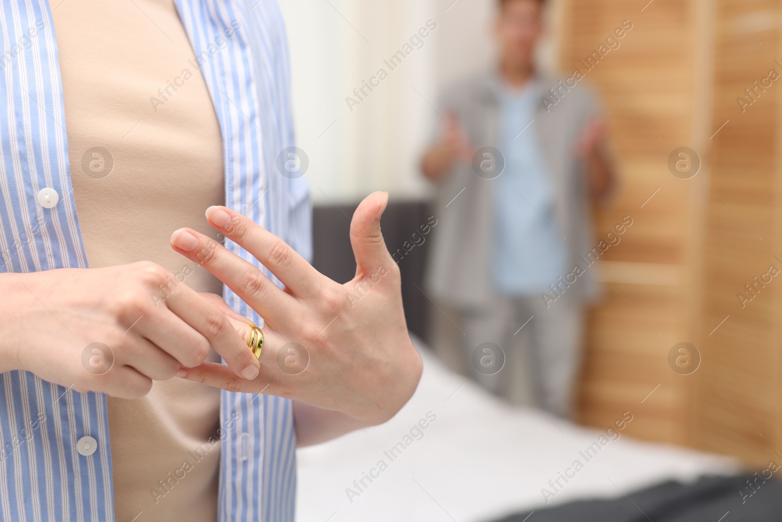 Woman taking off engagement ring after her husband's betrayal indoors, selective focus Photo of Woman taking off engagement ring after her husband's betrayal indoors, selective focus