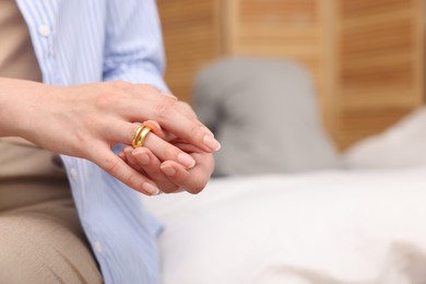 Photo of Woman taking off engagement ring after her husband's betrayal indoors, selective focus