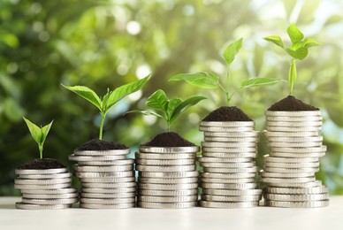 Image of Savings concept. Stacked coins with sprouts on table