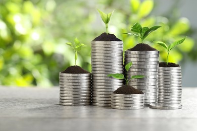 Image of Savings concept. Stacked coins with sprouts on table
