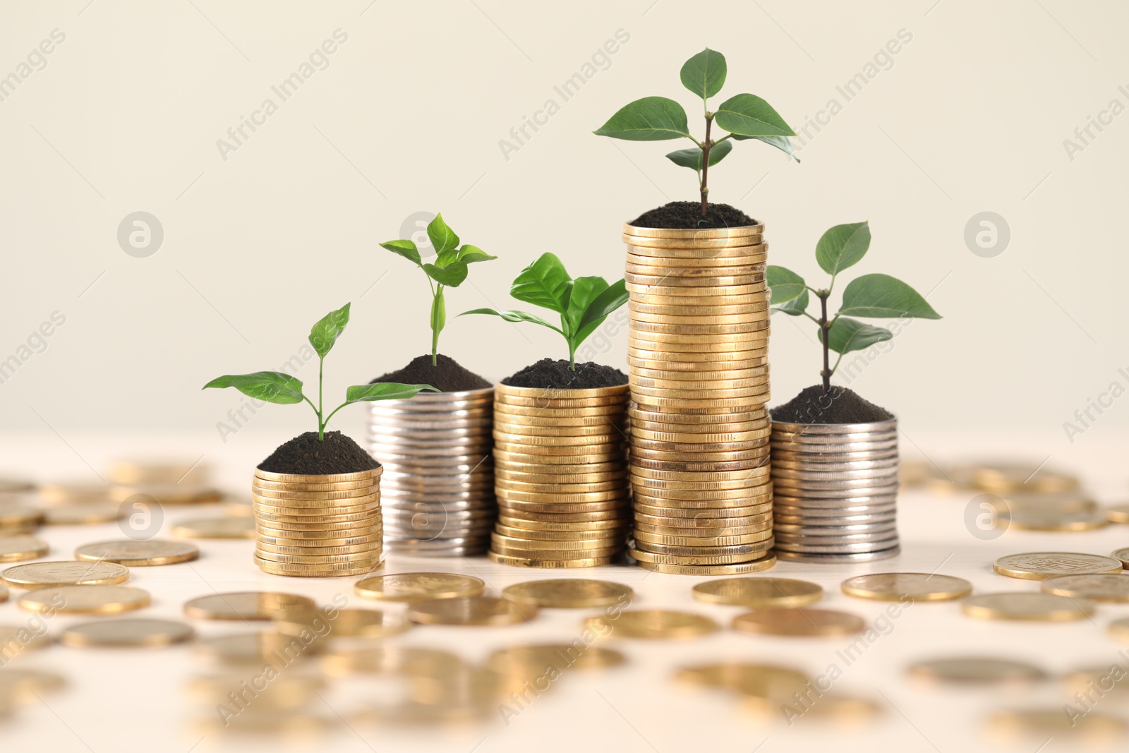 Image of Savings concept. Stacked coins with sprouts on table