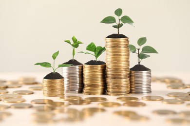 Image of Savings concept. Stacked coins with sprouts on table