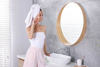 Photo of Getting ready. Young woman brushing her teeth near mirror at home