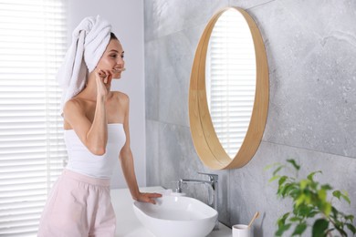 Photo of Getting ready. Young woman brushing her teeth near mirror at home