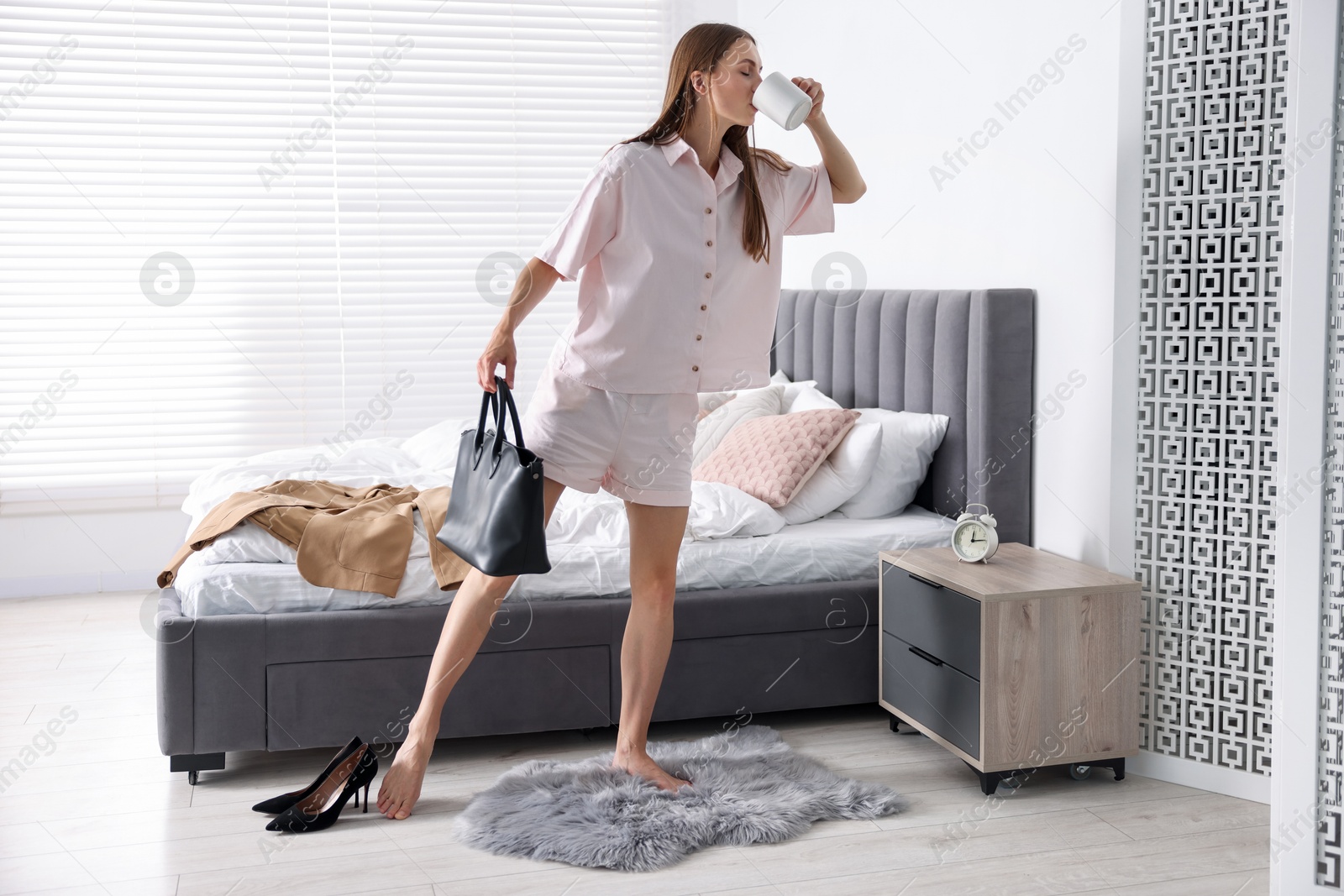 Young woman with cup of coffee getting ready at home Photo of Young woman with cup of coffee getting ready at home