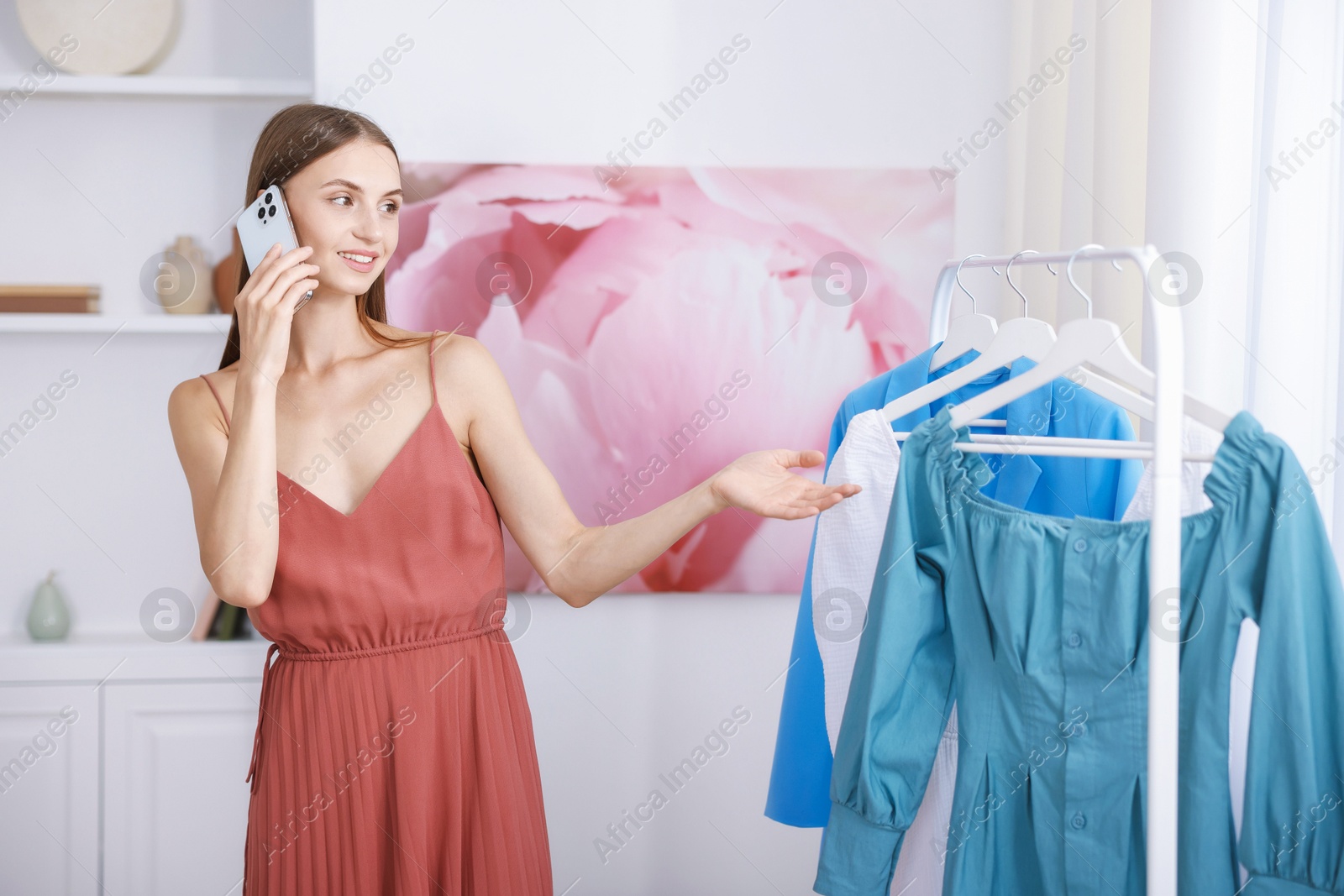 Photo of Getting ready. Young woman choosing clothes at home