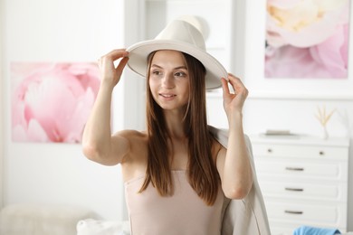 Photo of Getting ready. Young woman in stylish clothes at home