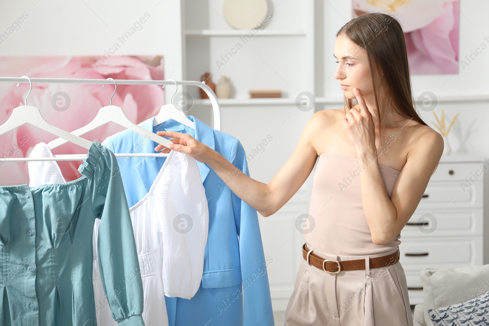 Getting ready. Young woman choosing clothes at home Photo of Getting ready. Young woman choosing clothes at home