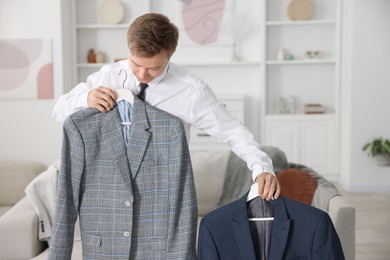 Photo of Getting ready. Young man choosing clothes at home