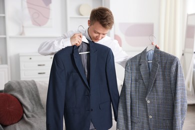 Photo of Getting ready. Young man choosing clothes at home
