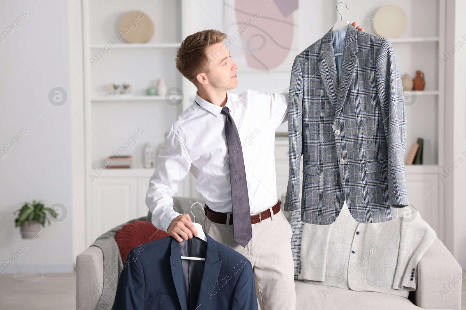 Photo of Getting ready. Young man choosing clothes at home