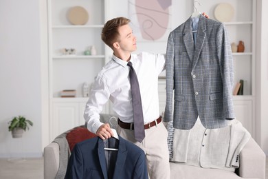 Photo of Getting ready. Young man choosing clothes at home