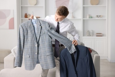 Photo of Getting ready. Young man choosing clothes at home