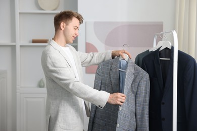 Photo of Getting ready. Young man choosing clothes at home