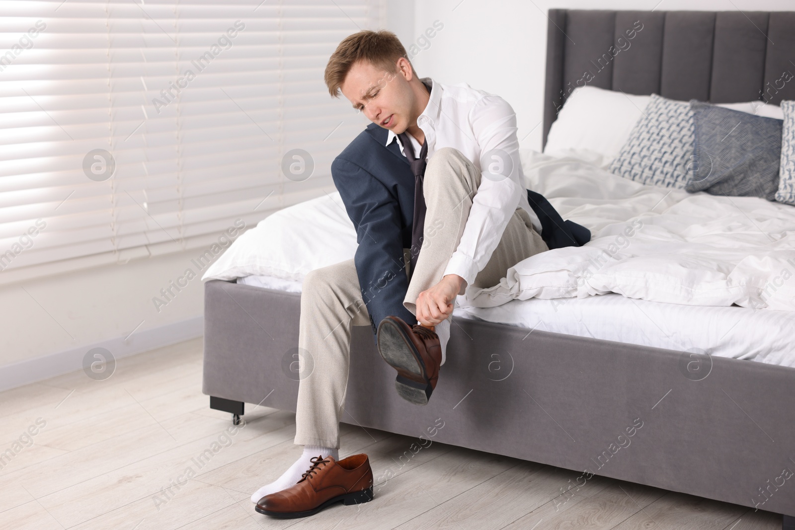 Getting ready. Young man putting on stylish shoes at home Photo of Getting ready. Young man putting on stylish shoes at home