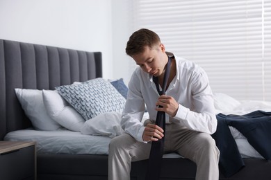 Photo of Sad young man getting ready at home
