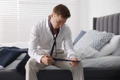 Photo of Sad young man getting ready at home