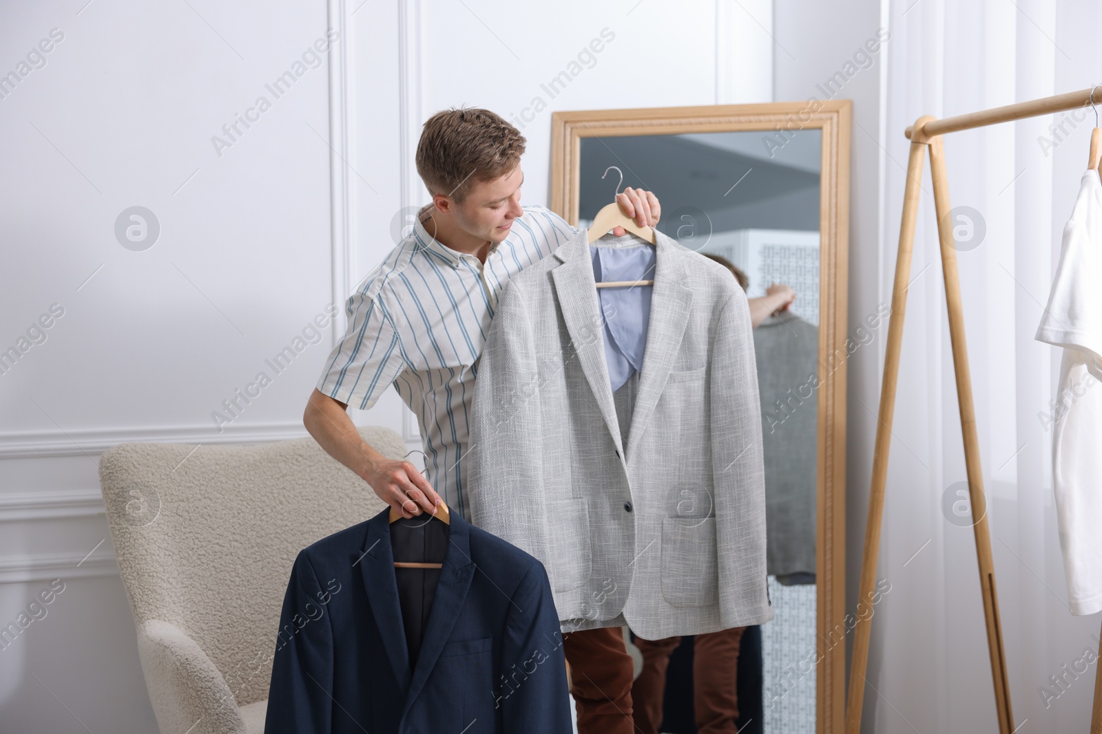 Photo of Getting ready. Young man choosing clothes at home