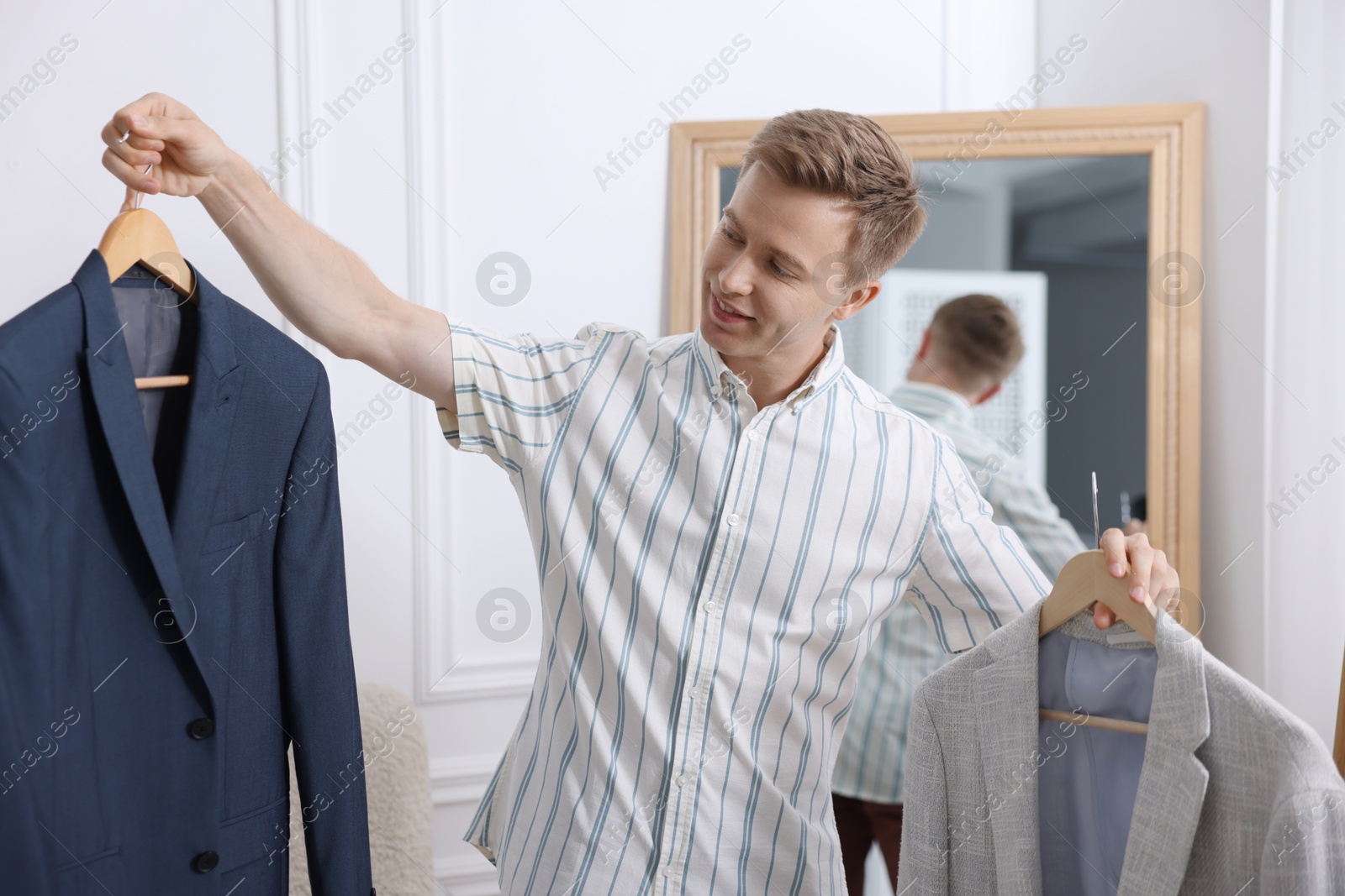 Getting ready. Young man choosing clothes at home Photo of Getting ready. Young man choosing clothes at home