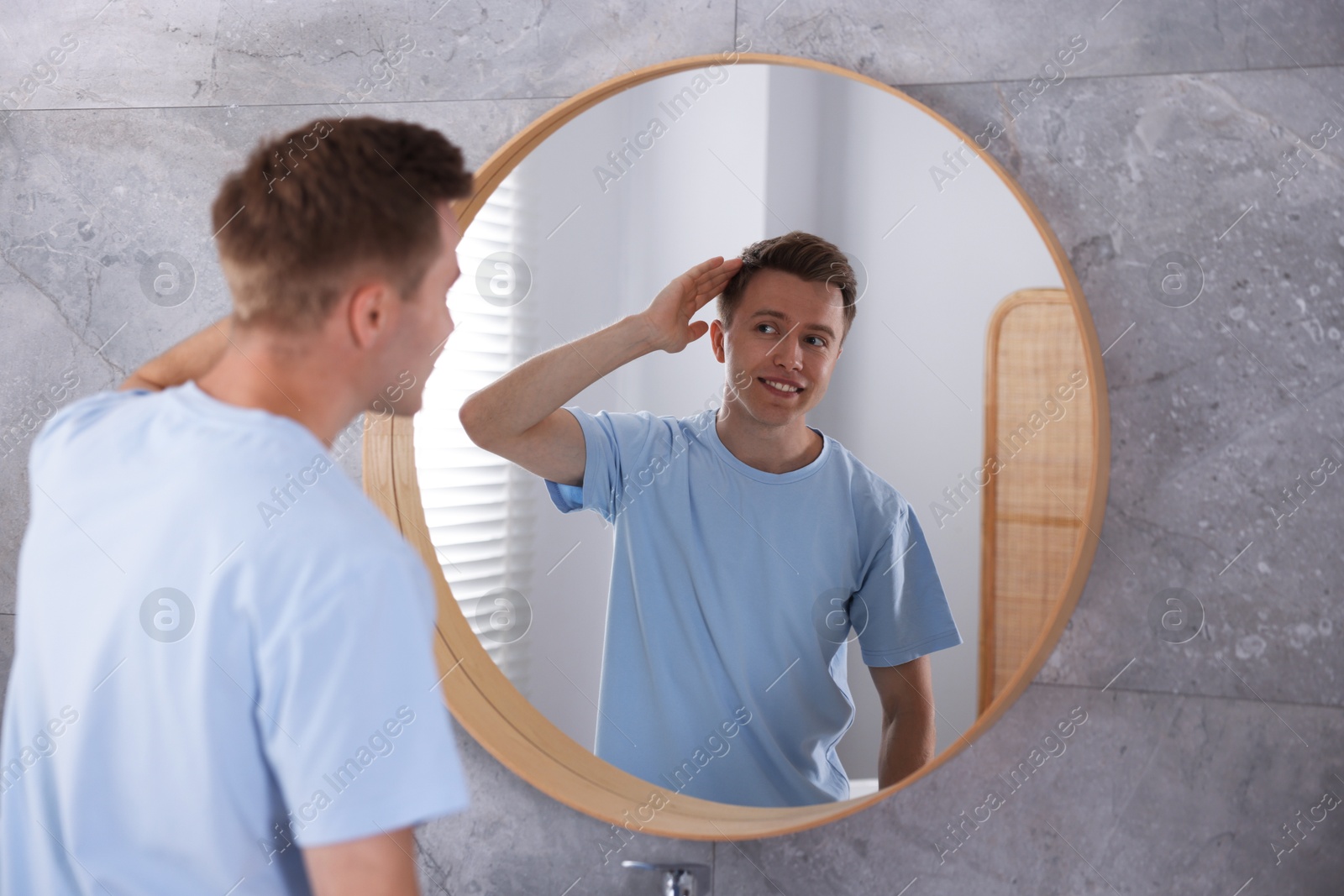 Young man getting ready near mirror at home Photo of Young man getting ready near mirror at home
