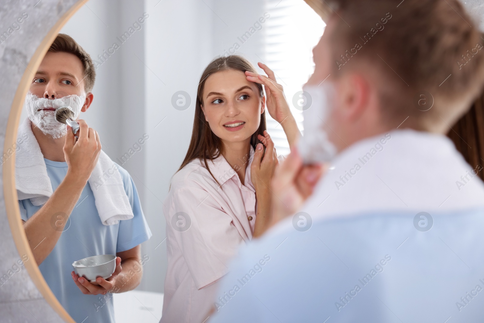 Young couple getting ready together near mirror at home Photo of Young couple getting ready together near mirror at home