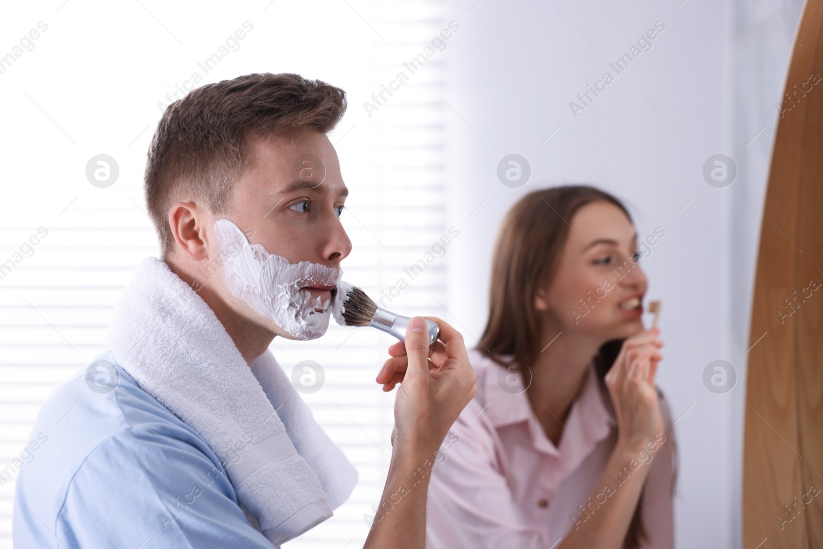 Young couple getting ready together near mirror at home Photo of Young couple getting ready together near mirror at home