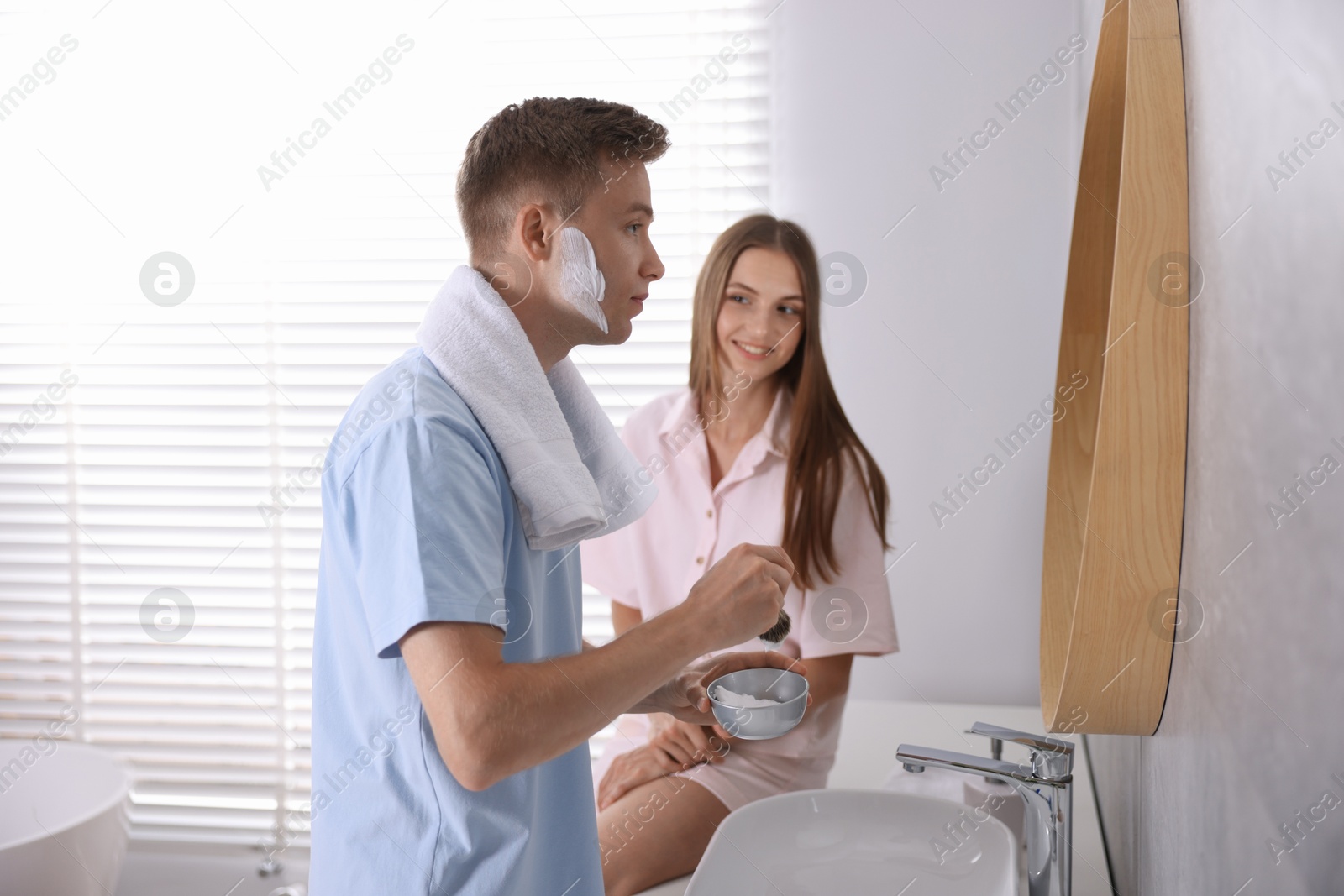 Young couple getting ready together near mirror at home Photo of Young couple getting ready together near mirror at home