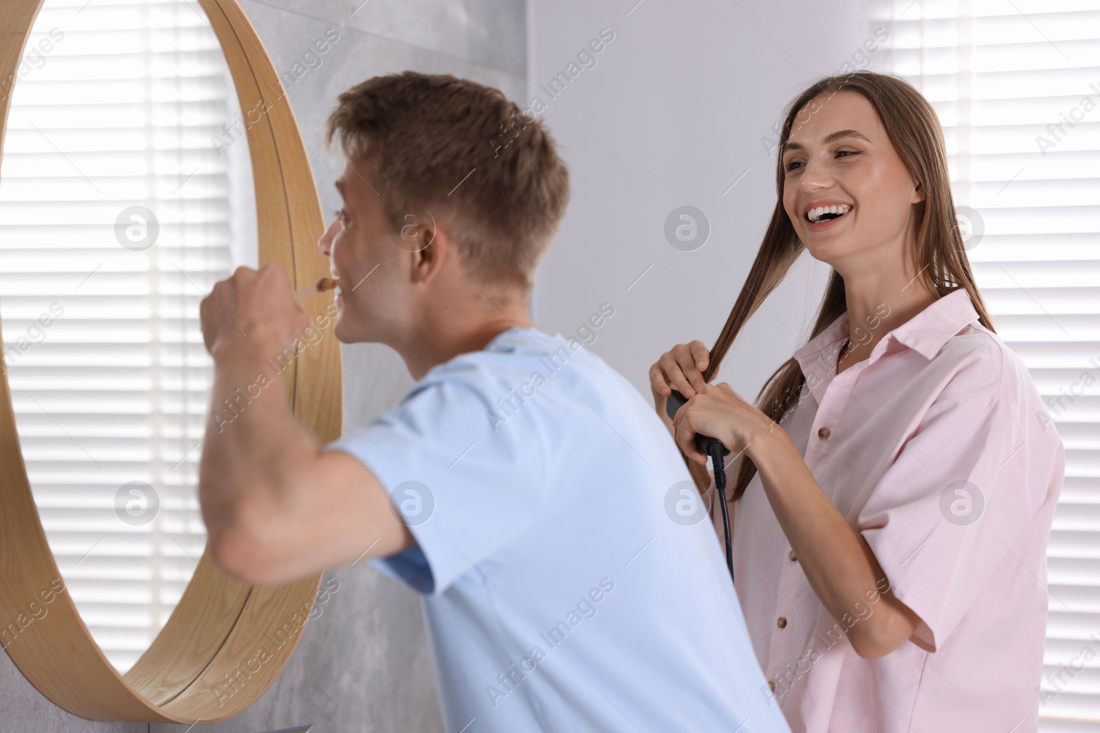 Young couple getting ready together near mirror at home Photo of Young couple getting ready together near mirror at home