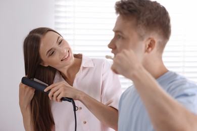 Photo of Young couple getting ready together near mirror at home