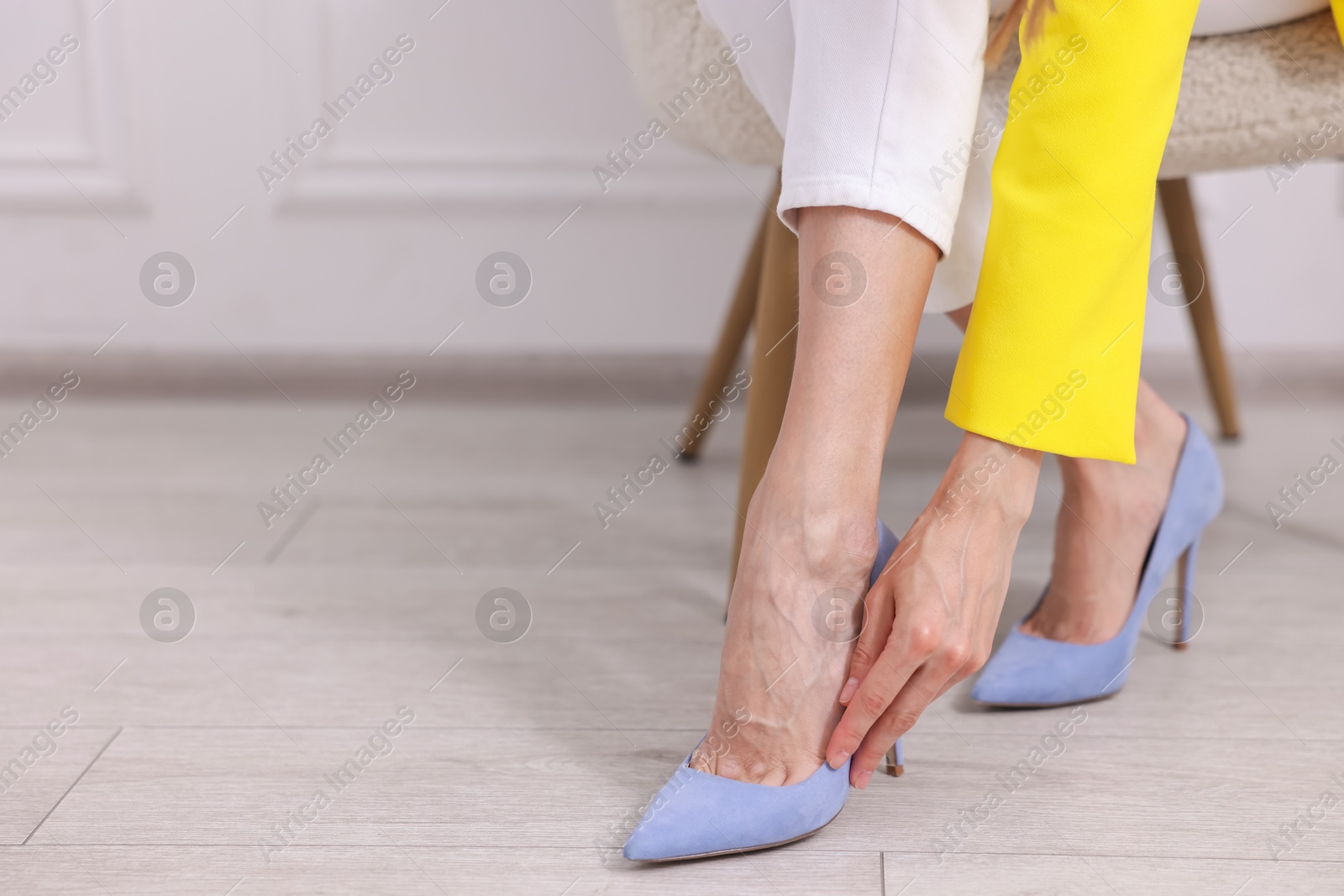 Getting ready. Young woman putting on high heeled shoes at home, closeup. Space for text Photo of Getting ready. Young woman putting on high heeled shoes at home, closeup. Space for text
