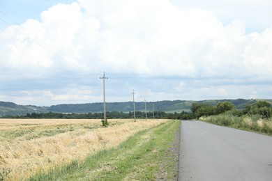 Photo of Beautiful wheat field and road under cloudy sky