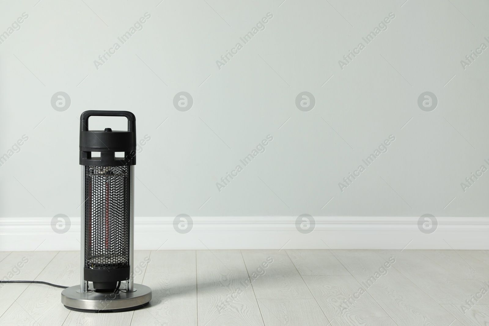 Photo of New modern electric heater on floor in room, space for text