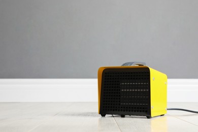 Photo of New modern electric heater on floor in room, space for text