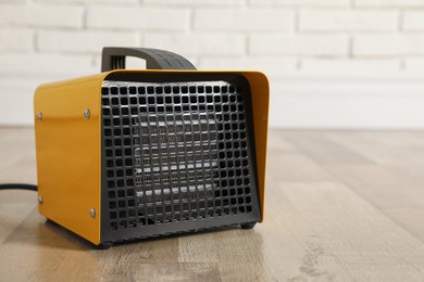 Photo of New modern electric heater on floor in room, space for text