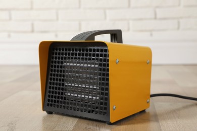 Photo of New modern electric heater on floor in room