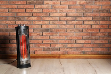 Photo of New modern electric heater on floor in room, space for text