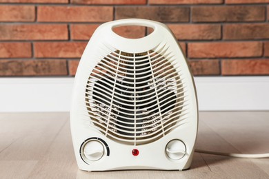 Photo of Modern electric fan heater on floor in room