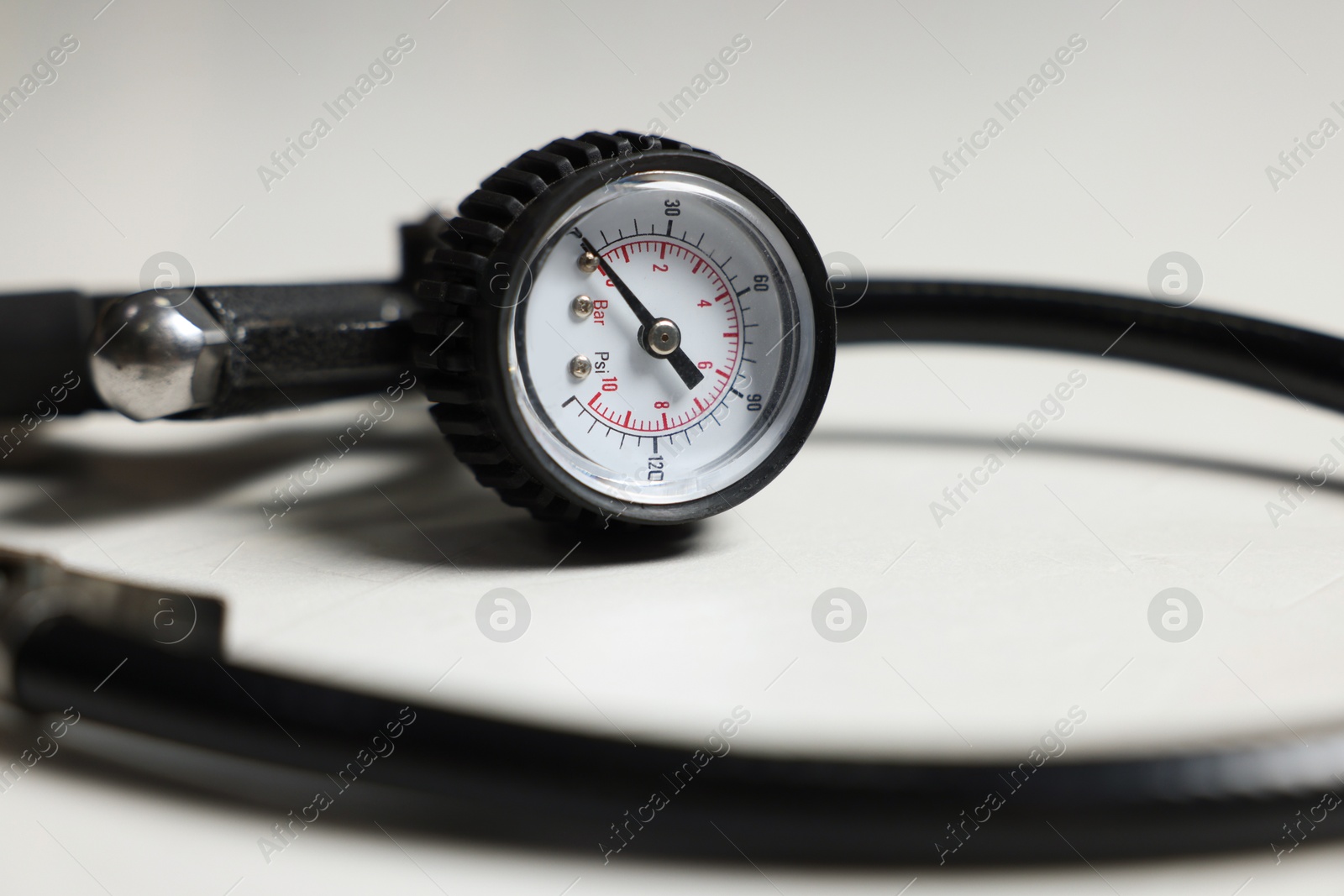 One tire inflation gun with gauge on light background, closeup Photo of One tire inflation gun with gauge on light background, closeup