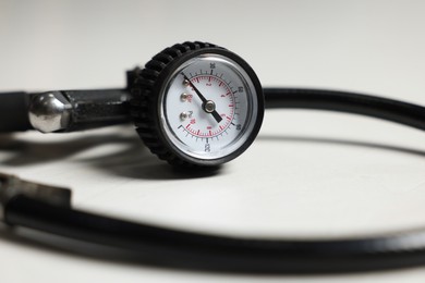 Photo of One tire inflation gun with gauge on light background, closeup