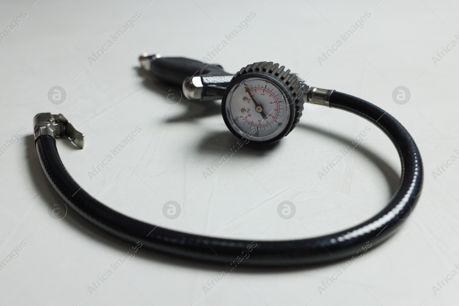 One tire inflation gun with gauge on light background, closeup Photo of One tire inflation gun with gauge on light background, closeup