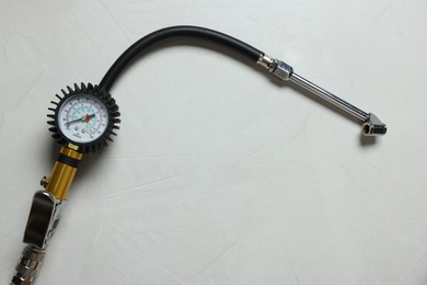 Photo of One tire inflation gun with gauge on light background, top view. Space for text